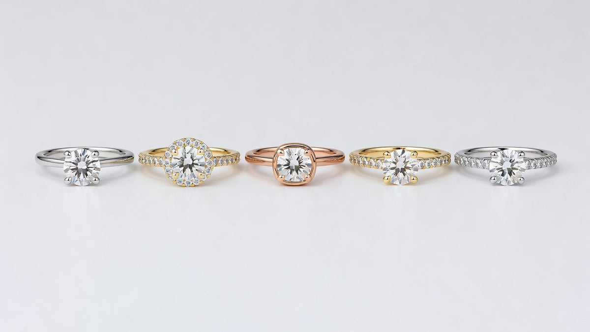 Five moissanite rings in different settings and metals arranged on a white surface for comparison