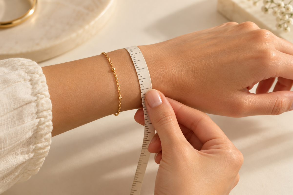 A wrist being measured beside a delicate bracelet