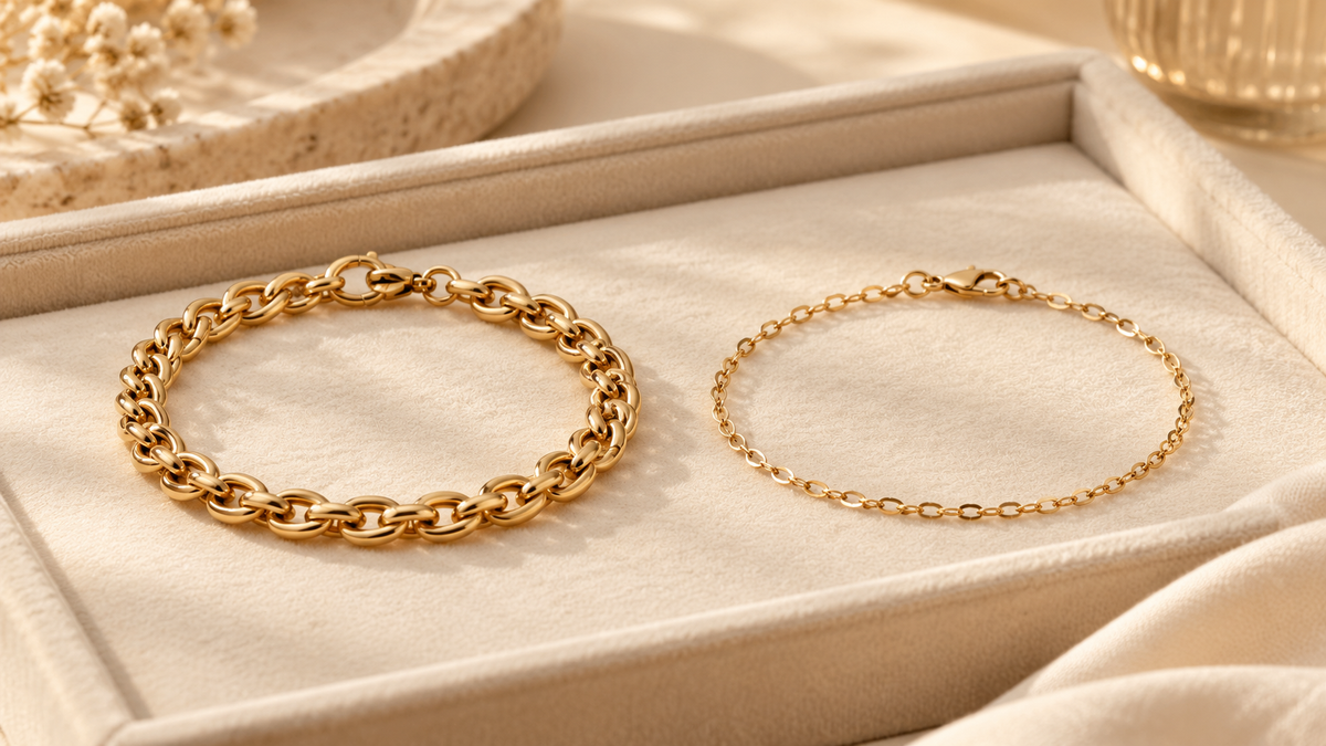 Two unbranded gold-coloured chain bracelets arranged side by side in a jewelry tray