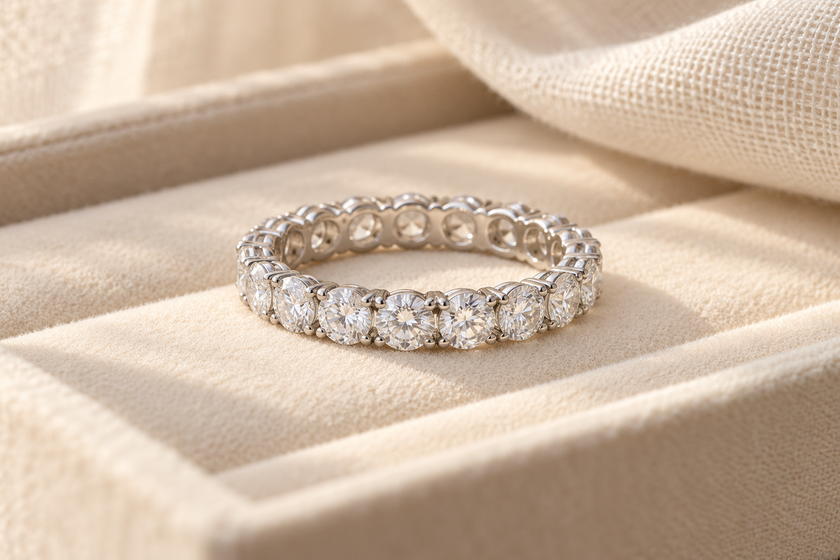 Clear gemstone eternity-style anniversary band on a warm ivory jewelry tray