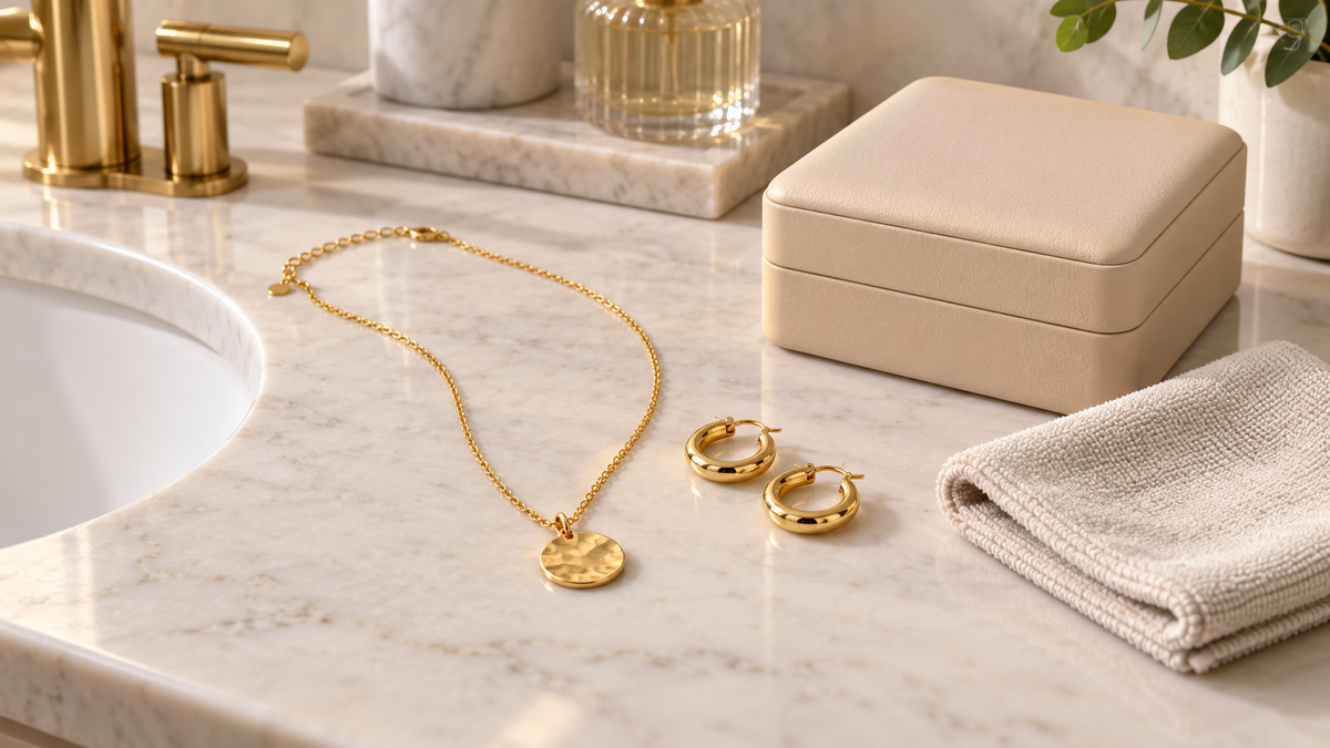 Gold-coloured necklace and earrings kept dry beside a jewelry box and microfiber cloth