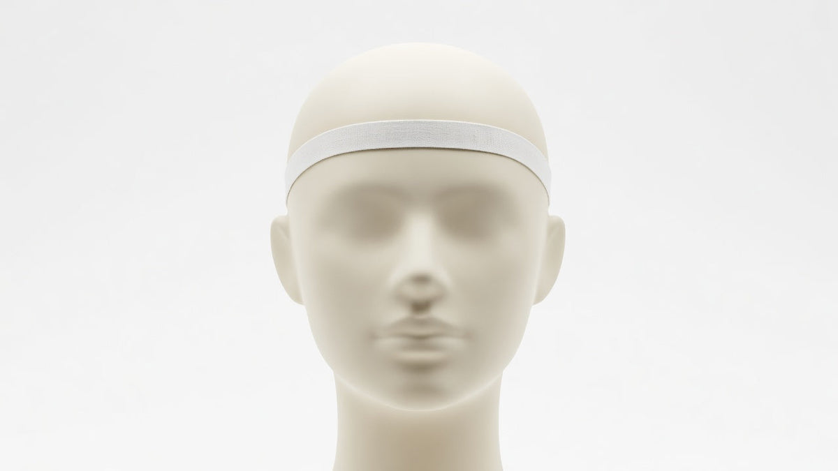 A soft tape measure wrapped around a mannequin head at the front hairline above the ears